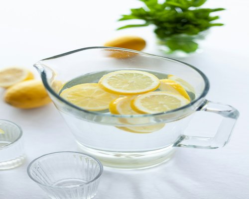 A pitcher of clean drinking water with lime slices next to it