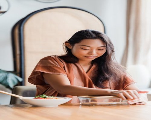 Person organizing clear glass containers with prepared balanced food components